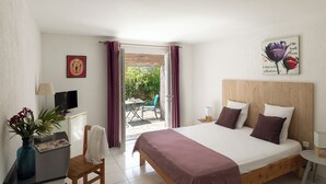A bedroom with a bed, a desk with a computer, a chair, a small table with a lamp, and a window with curtains. - Domaine Bocca Di Feno (Bonifacio)