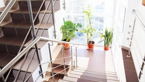 A staircase with metal railings and potted plants at the landing. - Elizeu Hotel (Bucharest)