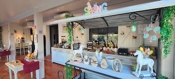 Una panadería con un letrero que dice 'PRIMAVERA', decorada con adornos de Pascua y una escultura de un caballo blanco.