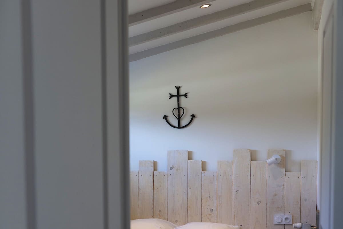 A bedroom with a bed, wooden headboard, and a door.