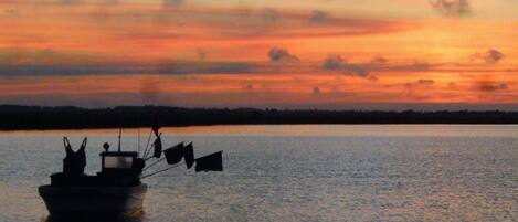 A boat on calm water during sunset.