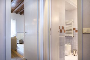 A bathroom with a bathtub, toilet, and a towel rack.