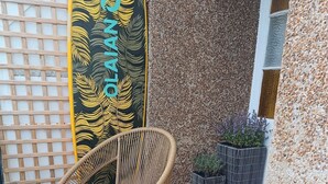 Wicker chairs, a round table, and a decorative wall with a surfboard. - Regency Rooms (Littlehampton)