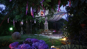 Een open tuin met een zithoek en decoratieve elementen zoals linten en lantaarns.