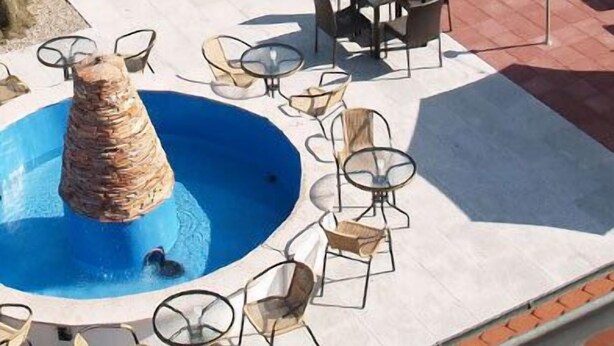 An outdoor pool area with a central water feature, surrounded by tables and chairs. - Hotel Restaurant Zum Ochsen (Bietigheim)