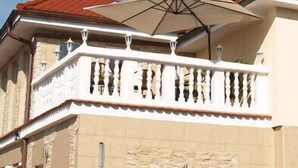A building with a balcony, a red-tiled roof, and a beige facade. - Hotel Restaurant Zum Ochsen (Bietigheim)