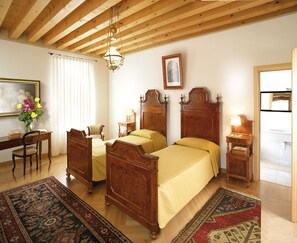 A traditional room with two wooden beds, a desk, and a chair. - Villa Busta Hotel (Montebelluna)