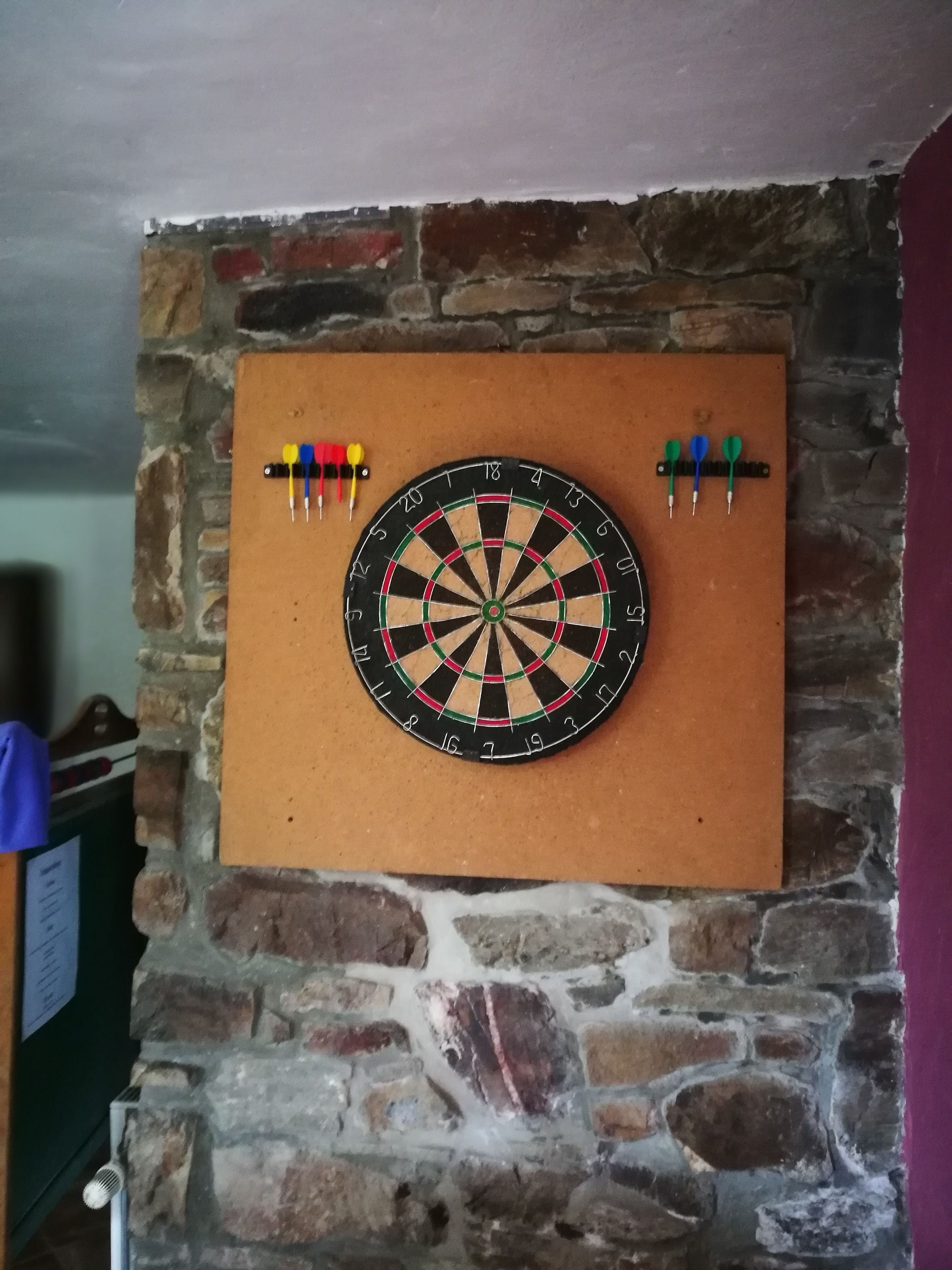 A dartboard mounted on a stone wall.
