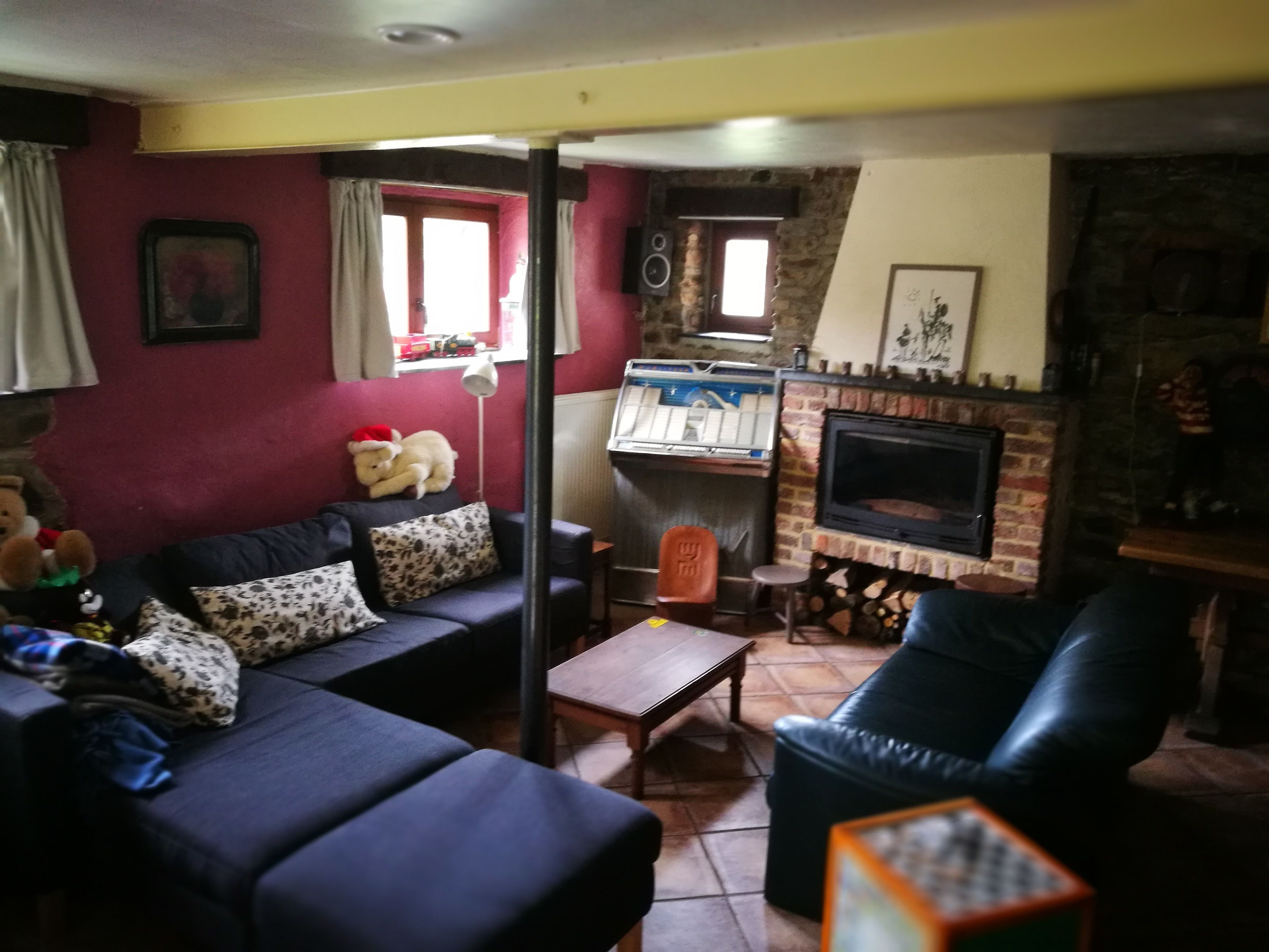 Una sala de estar con chimenea, un sofá, una mesita de centro y un televisor.
