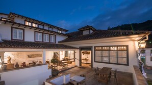A traditional building with a courtyard, a dining area, and a kitchen visible through the open doors. - Pousada do Mondego (Ouro Preto)