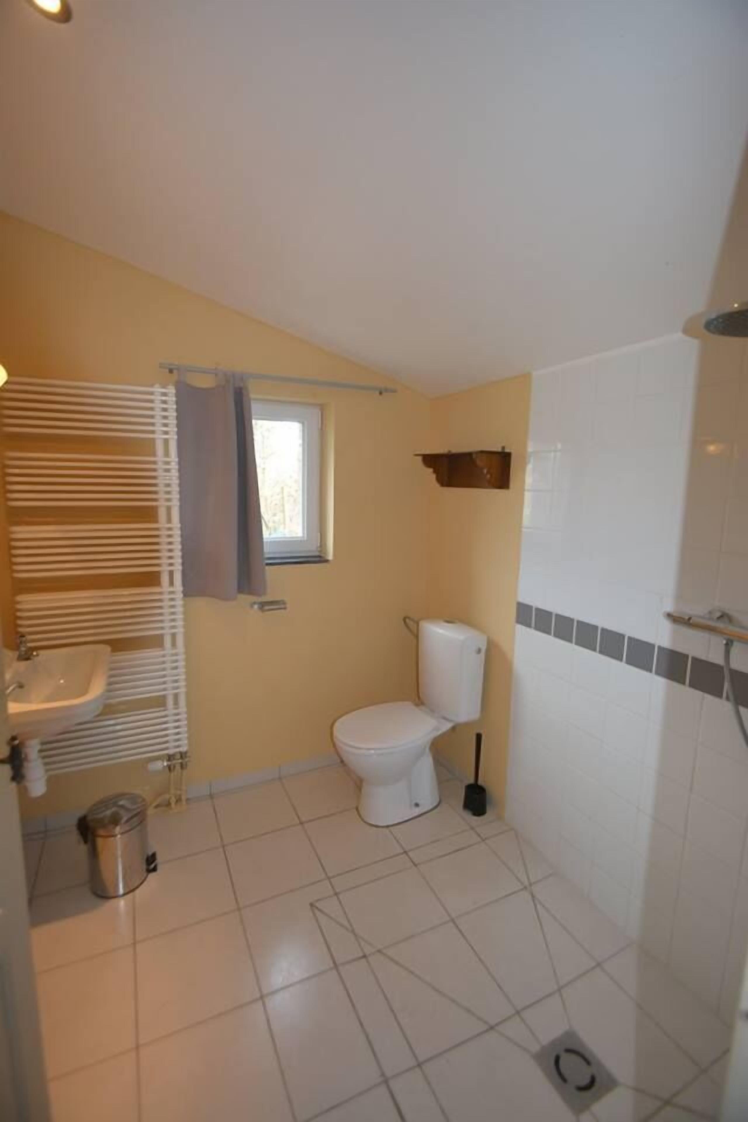 Un baño pequeño con inodoro, lavamanos y ducha.