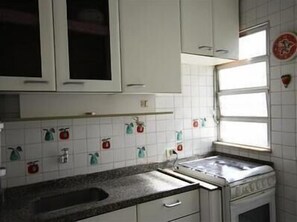 Eine Küche mit weißen Schränken, einem Spülbecken und einem Fenster mit Blick.