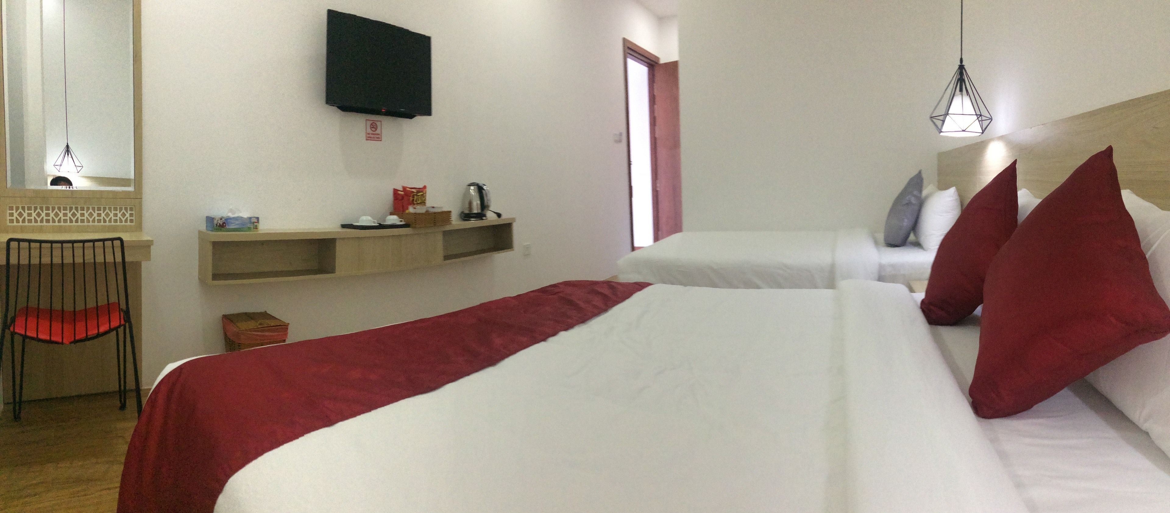 Ein Hotelzimmer mit Bett, Wandfernseher, kleinem Tisch mit Stuhl und Fenster mit Blick.