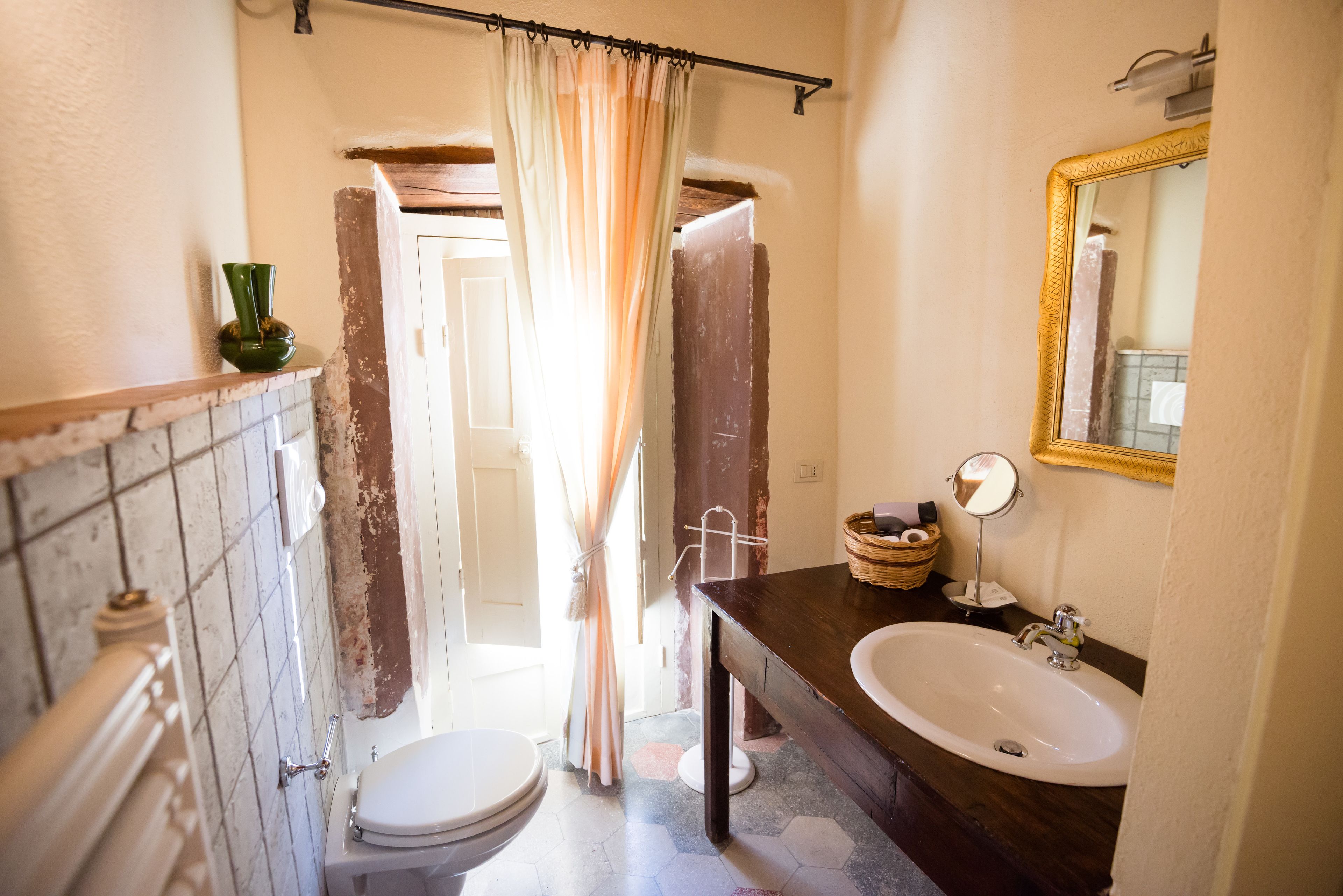 A bathroom with a toilet, sink, and shower curtain.