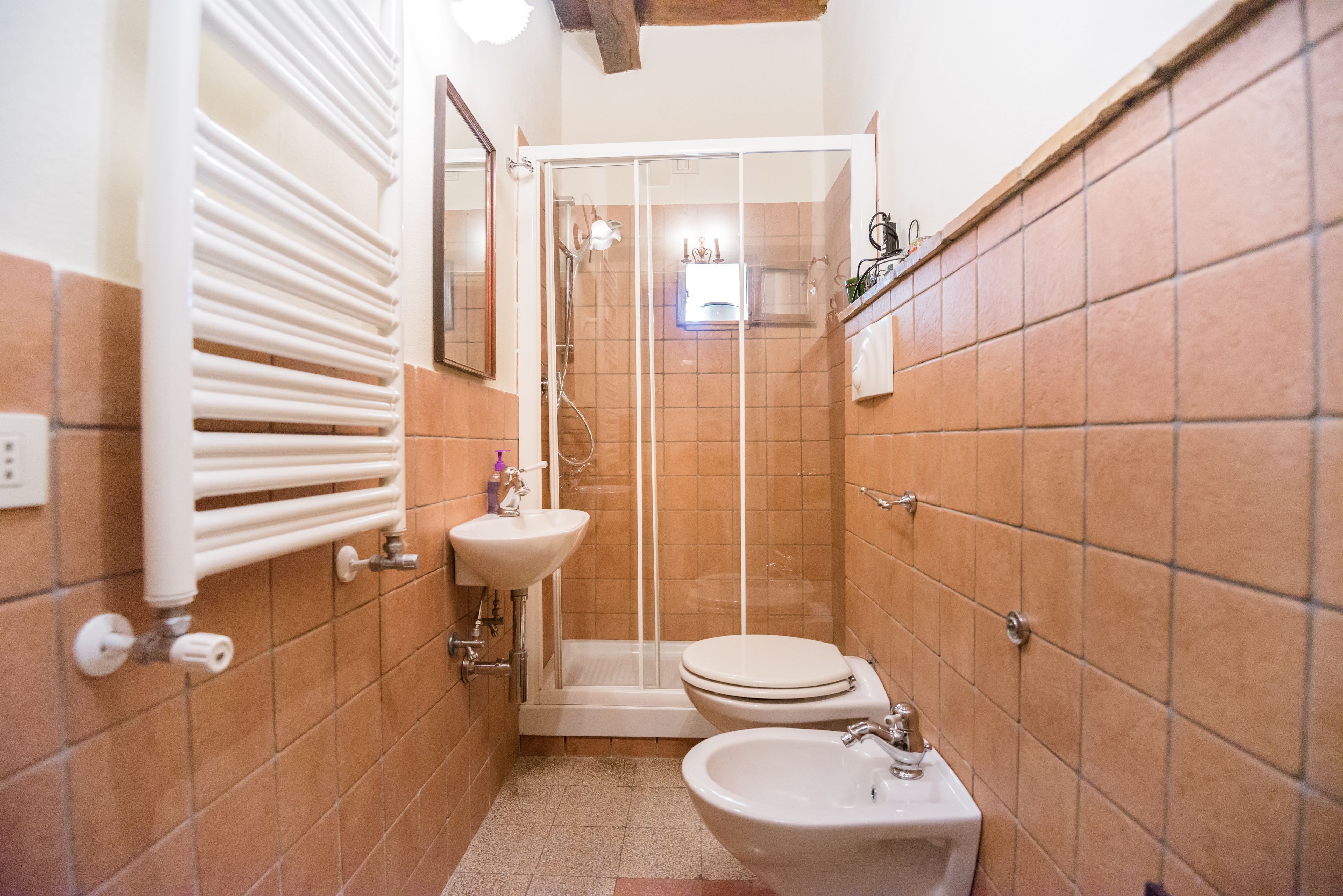 Ein kleines Badezimmer mit Dusche, Toilette und Waschbecken.