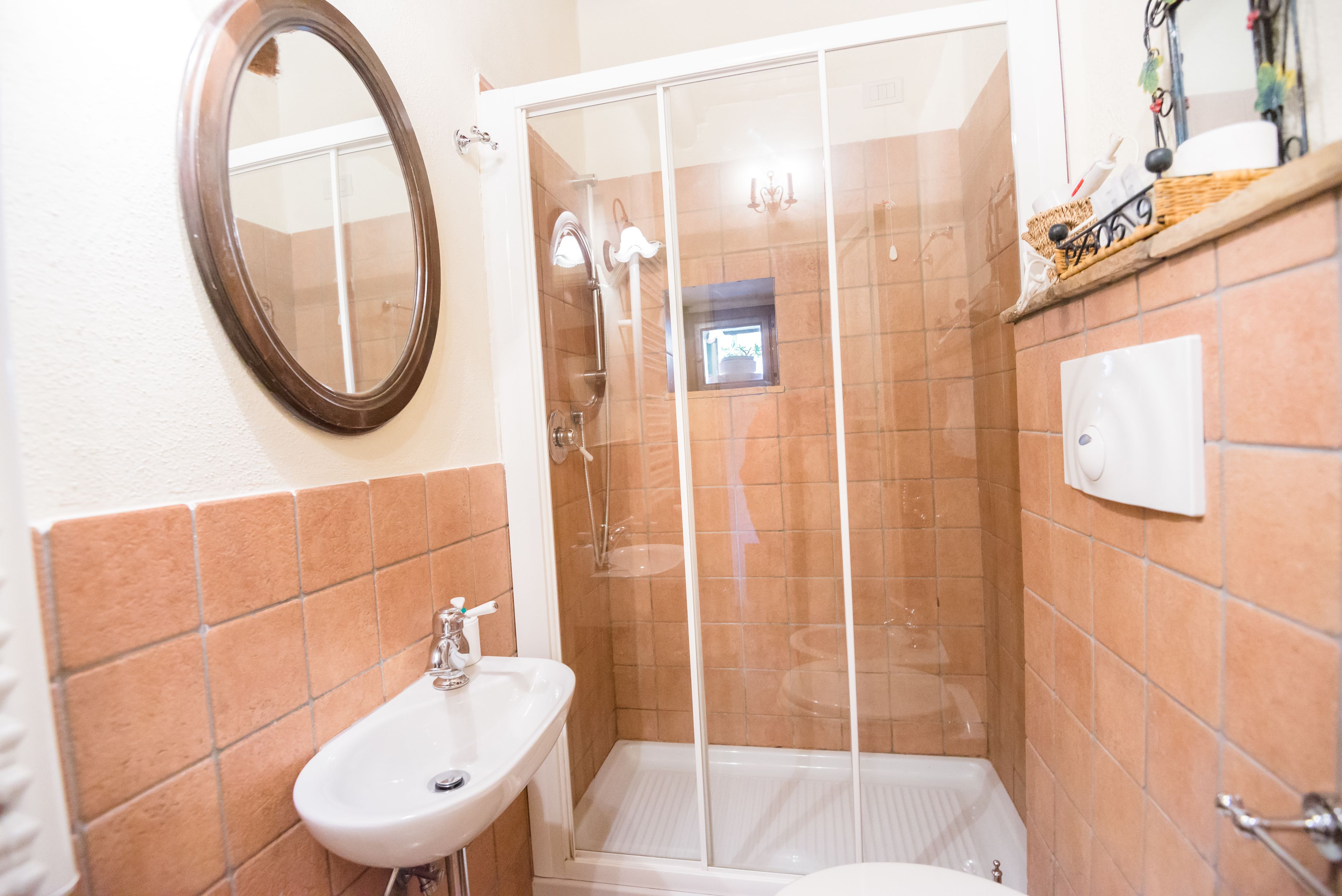 A bathroom with a white sink, a glass-enclosed shower, and a mirror on the wall.