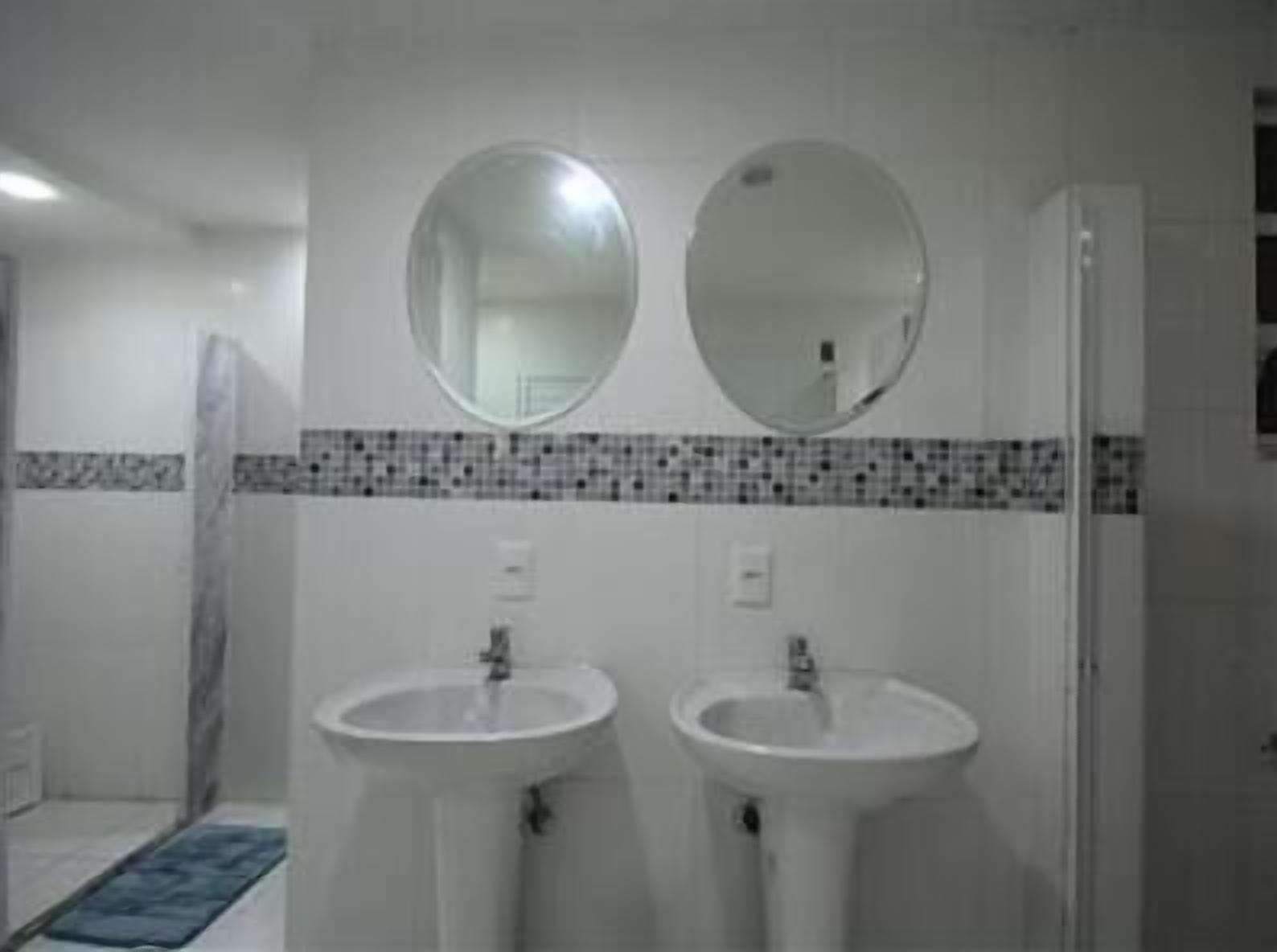 A bathroom with two sinks and two mirrors.