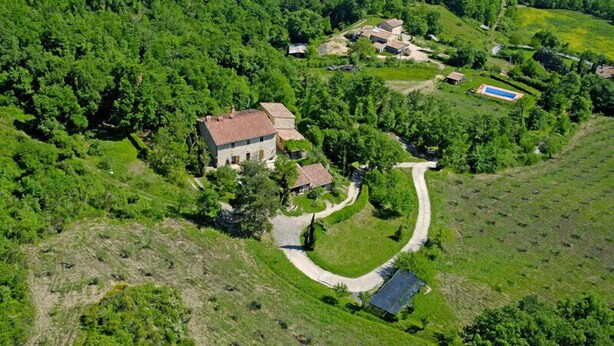 An aerial view of a rural property with a main house, smaller buildings, and a swimming pool. - Agriturismo Santa Caterina (Castelnuovo di Val di Cecina)