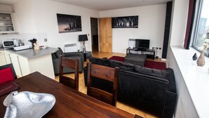 A modern living space with a dining area, kitchen, and seating area. - Cranbrook House Serviced Apartments (Nottingham)