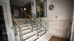 A staircase with glass railings and a brown doormat with the text "workhouse." - Cranbrook House Serviced Apartments (Nottingham)