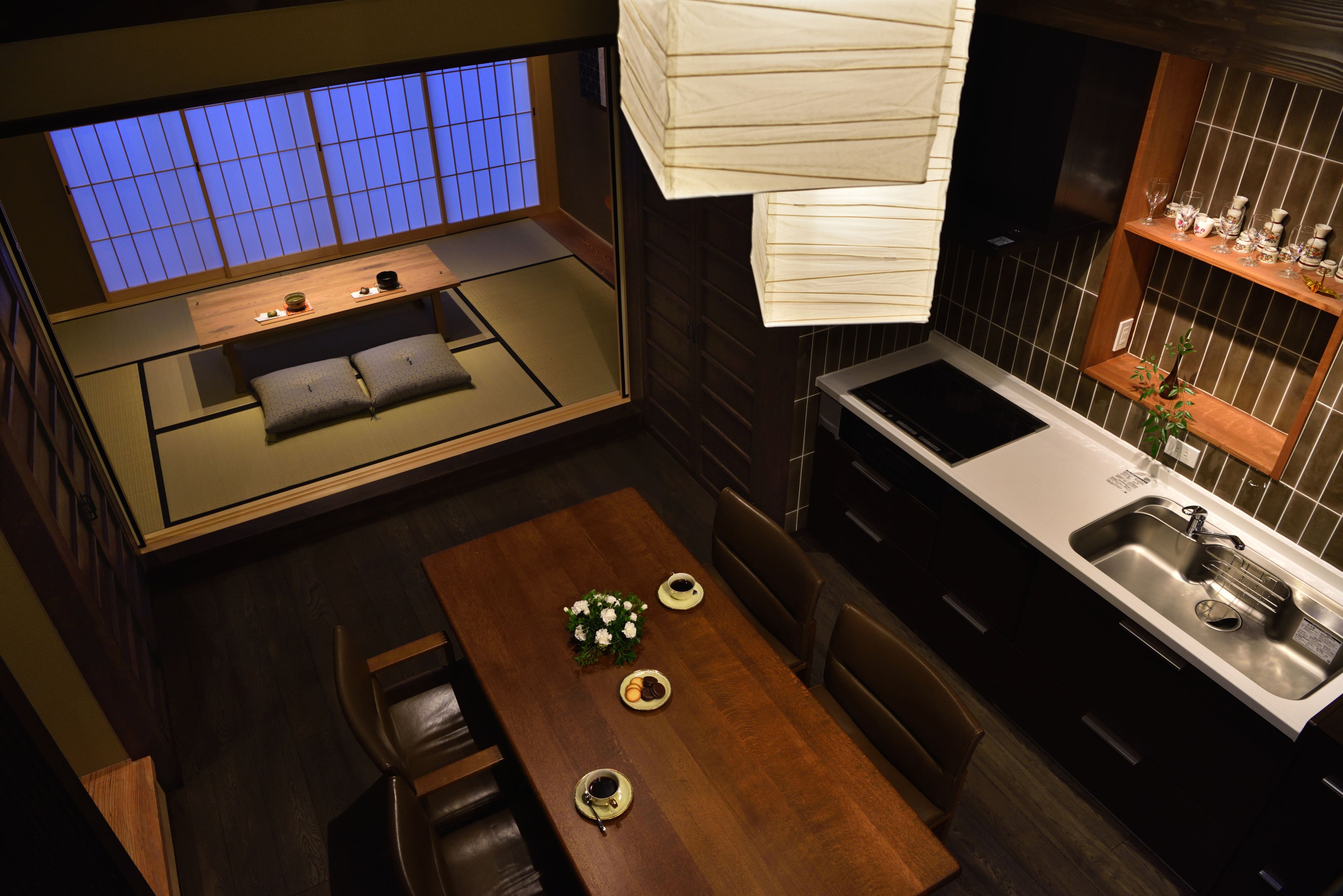 A modern kitchen with a wooden dining table, a built-in stove, and a sink.