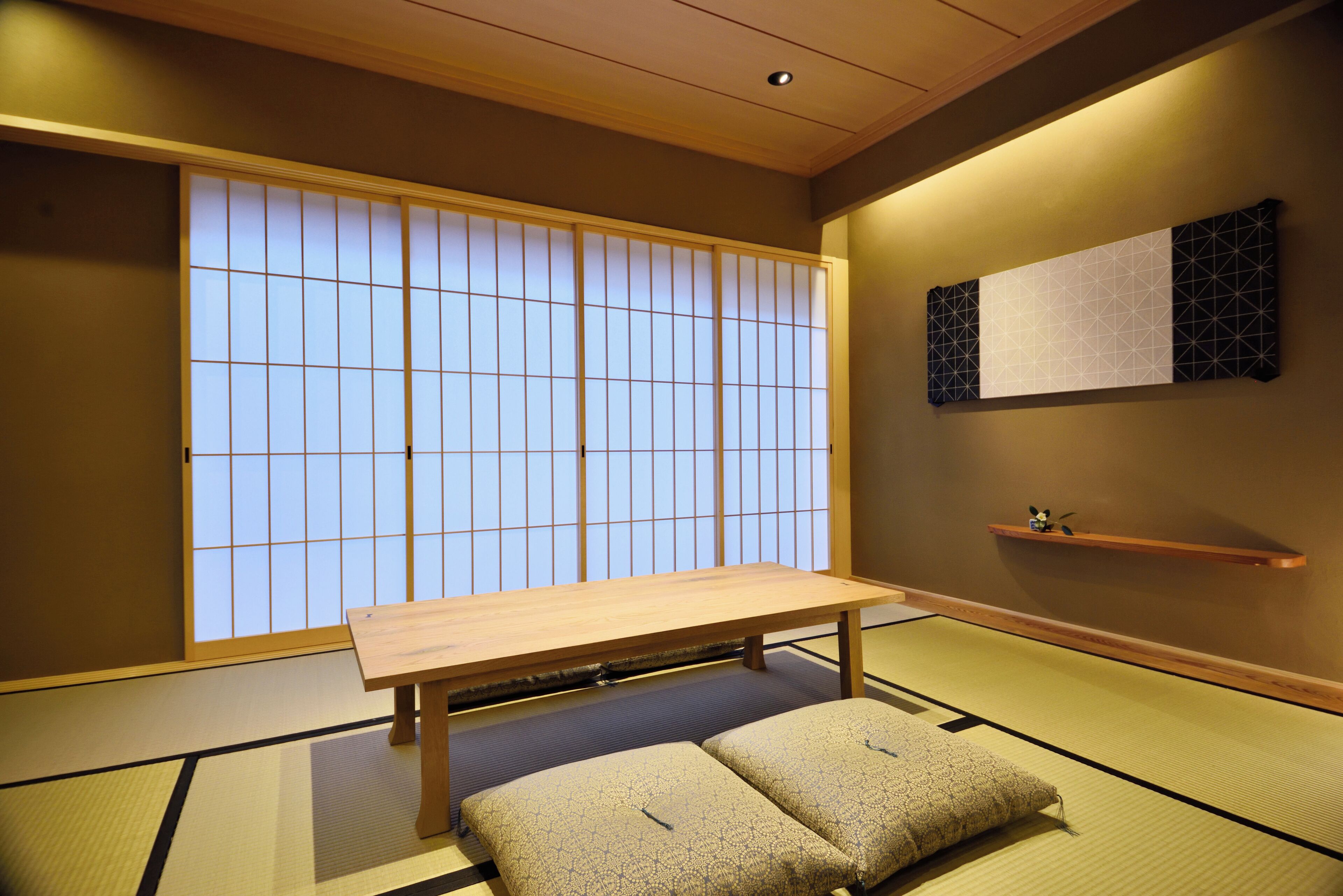 A traditional Japanese room with tatami flooring, a low wooden table, and shoji screens.