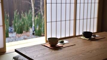 Una tradizionale stanza giapponese con pavimento in tatami, un tavolo di legno e un paravento shoji.