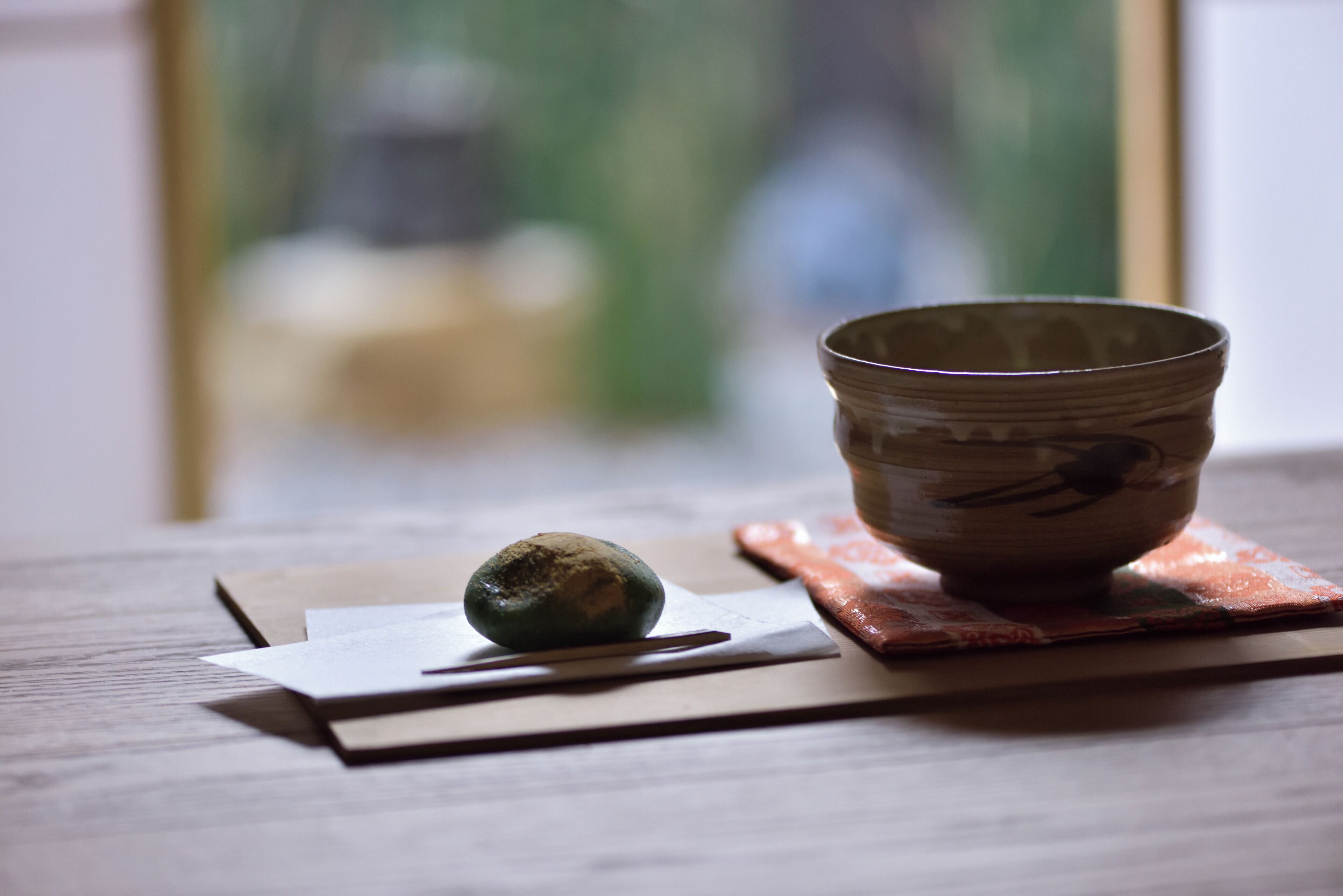 Un bol en céramique sur une table en bois, avec une serviette et des baguettes.