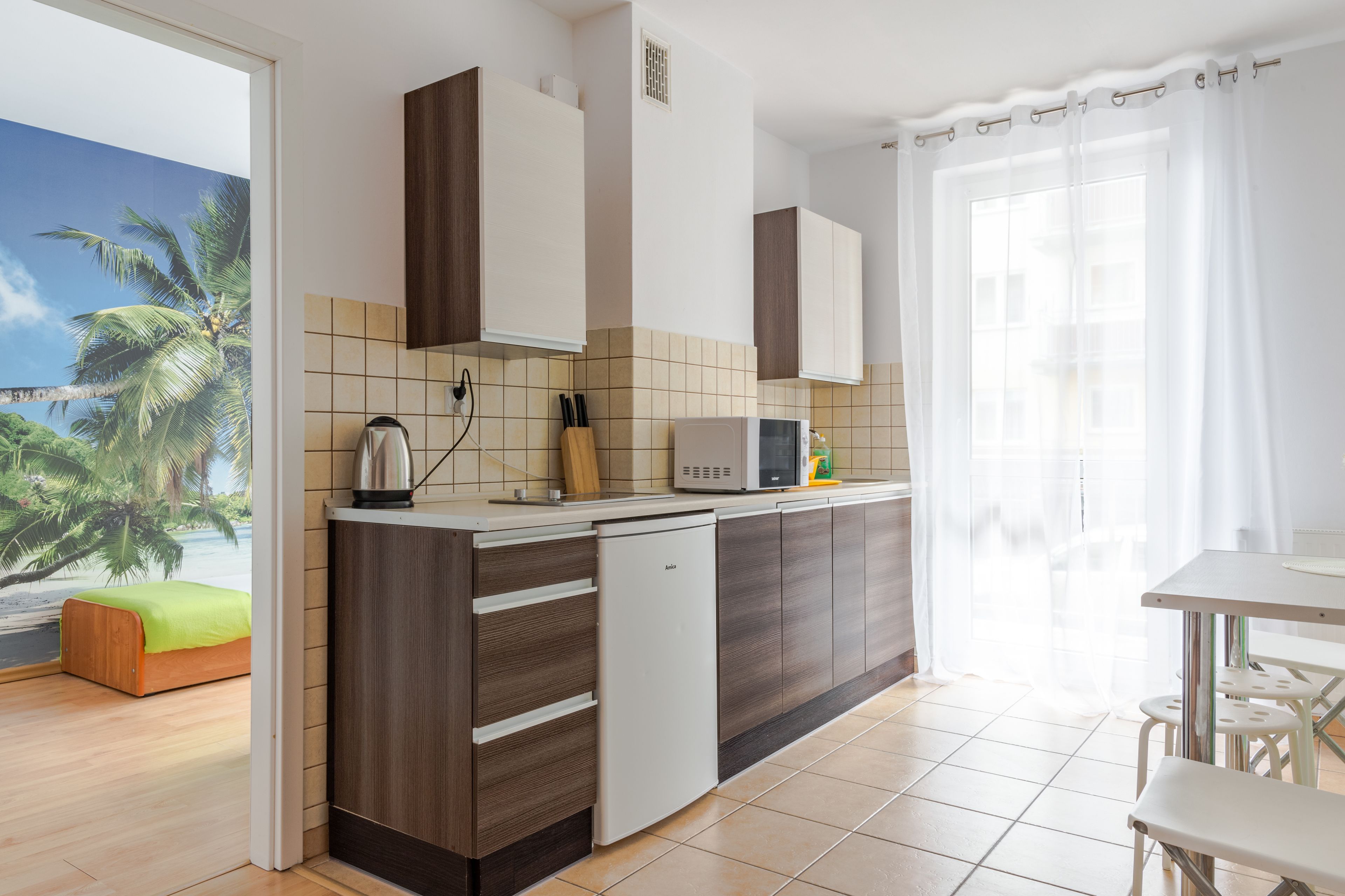 A modern kitchen with a built-in dishwasher, a microwave, and a small dining area with a table and chairs.