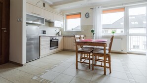 Cocina moderna con comedor, que incluye un refrigerador, horno y armarios de madera.