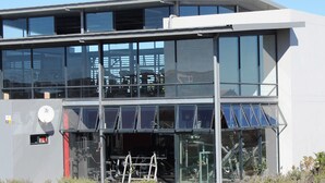 Un edificio moderno con amplios ventanales y techo plano.