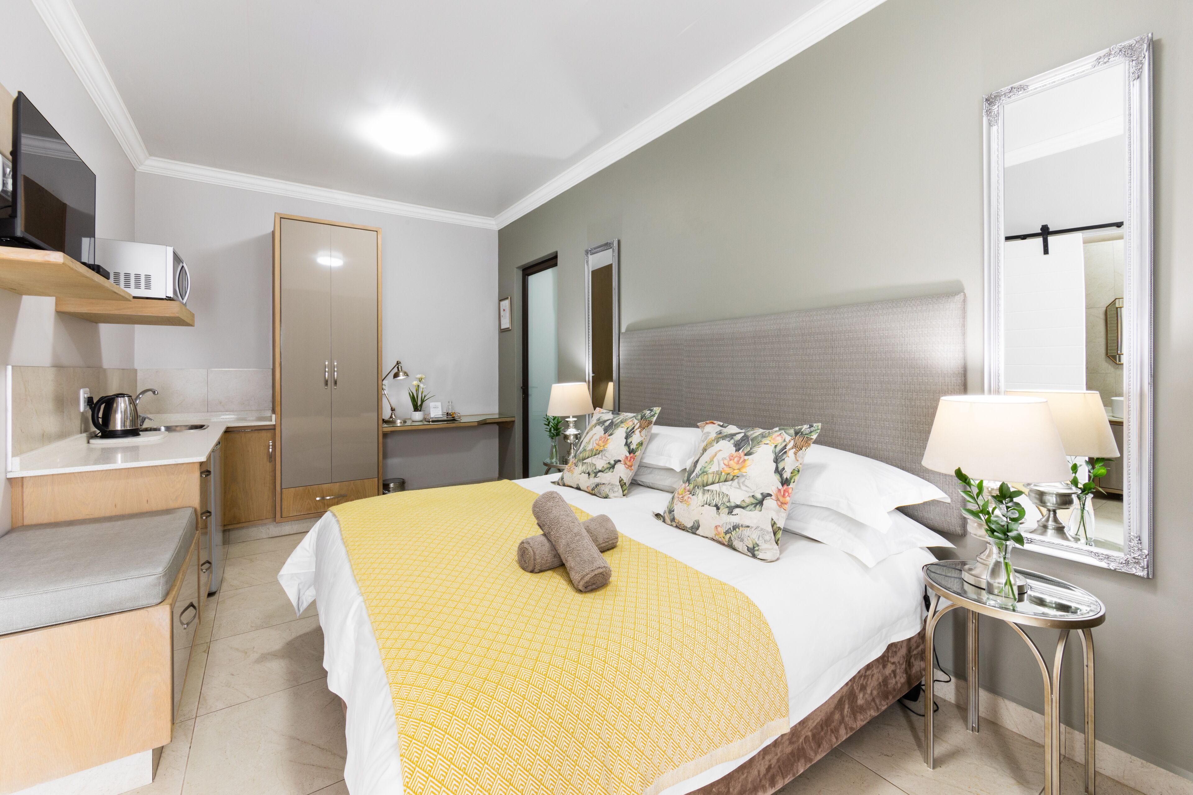 Ein Hotelzimmer mit Bett, Nachttisch und Spiegel.