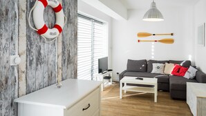 Una sala moderna con un sofá blanco, una mesa de centro y un flotador montado en la pared.
