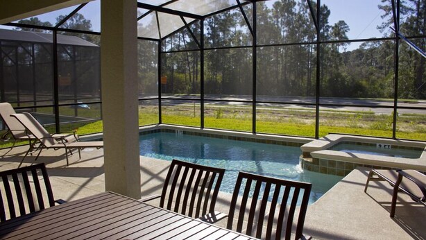 A covered outdoor pool area with a view of the surrounding landscape. - Paradise Palms 8948 (Kissimmee)