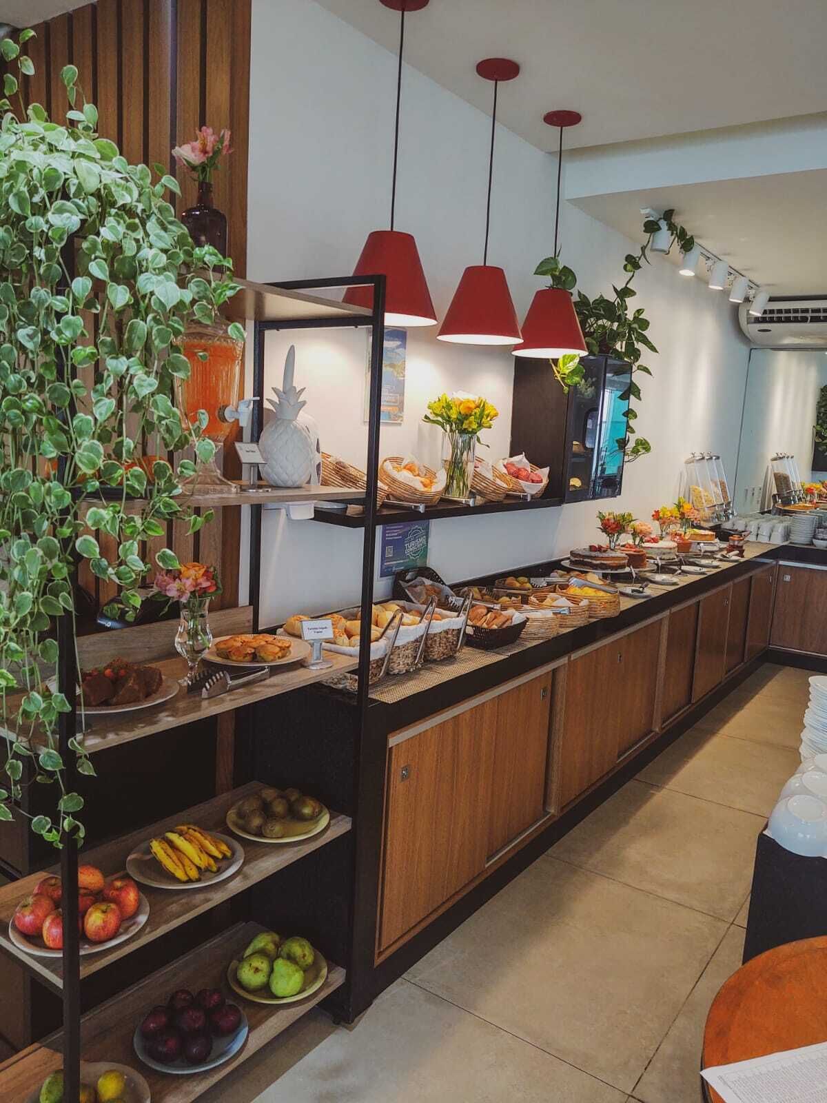 Un montaje de bufé con diversos alimentos, una exhibición de frutas y plantas colgantes.