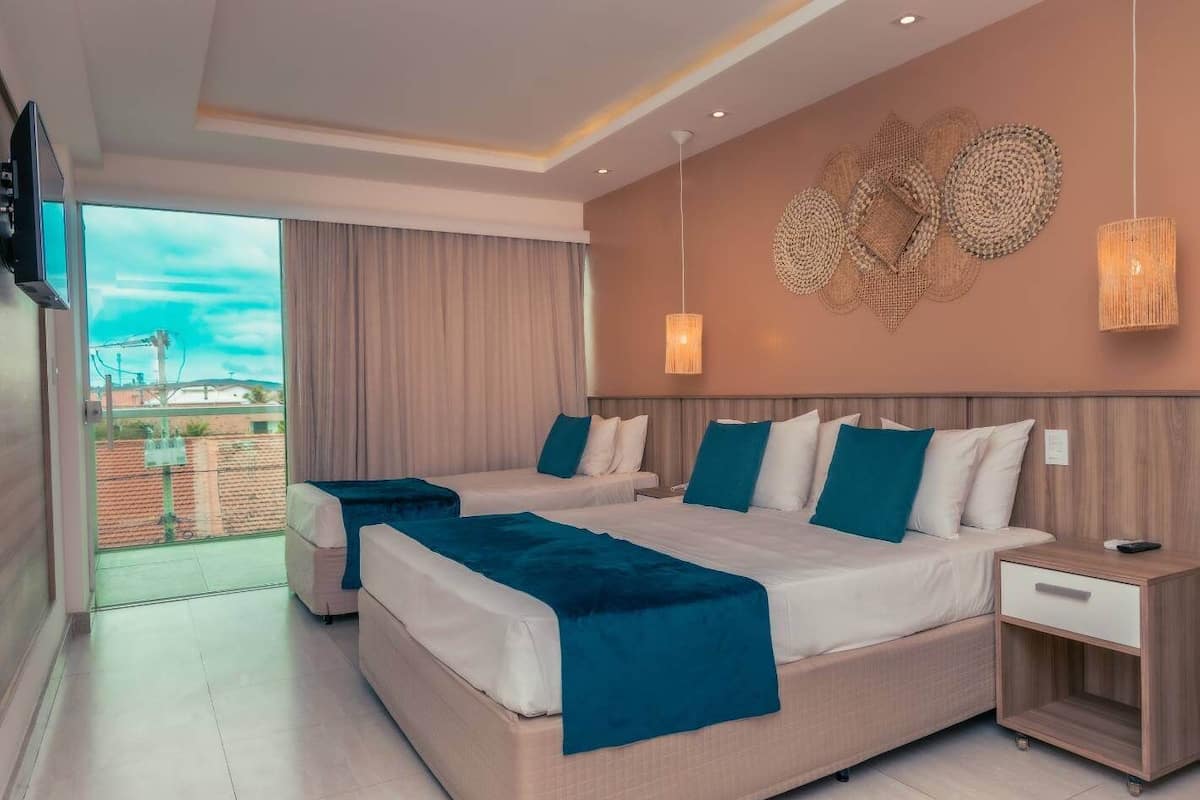 Une chambre d’hôtel moderne avec deux lits, un balcon et une vue sur la ville.