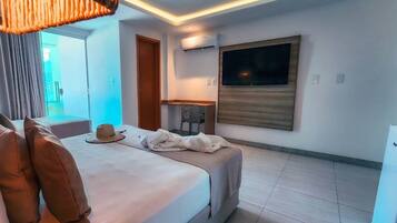 A modern hotel room with a bed, a desk, and a TV.
