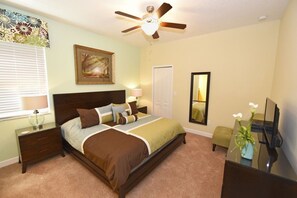 A bedroom with a bed, nightstands, a ceiling fan, a window with blinds, a door, a mirror, and a dresser. - Providence 2323EVDIL (Davenport)