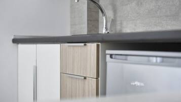 A modern kitchen with a stainless steel sink, wooden cabinets, and a built-in dishwasher.