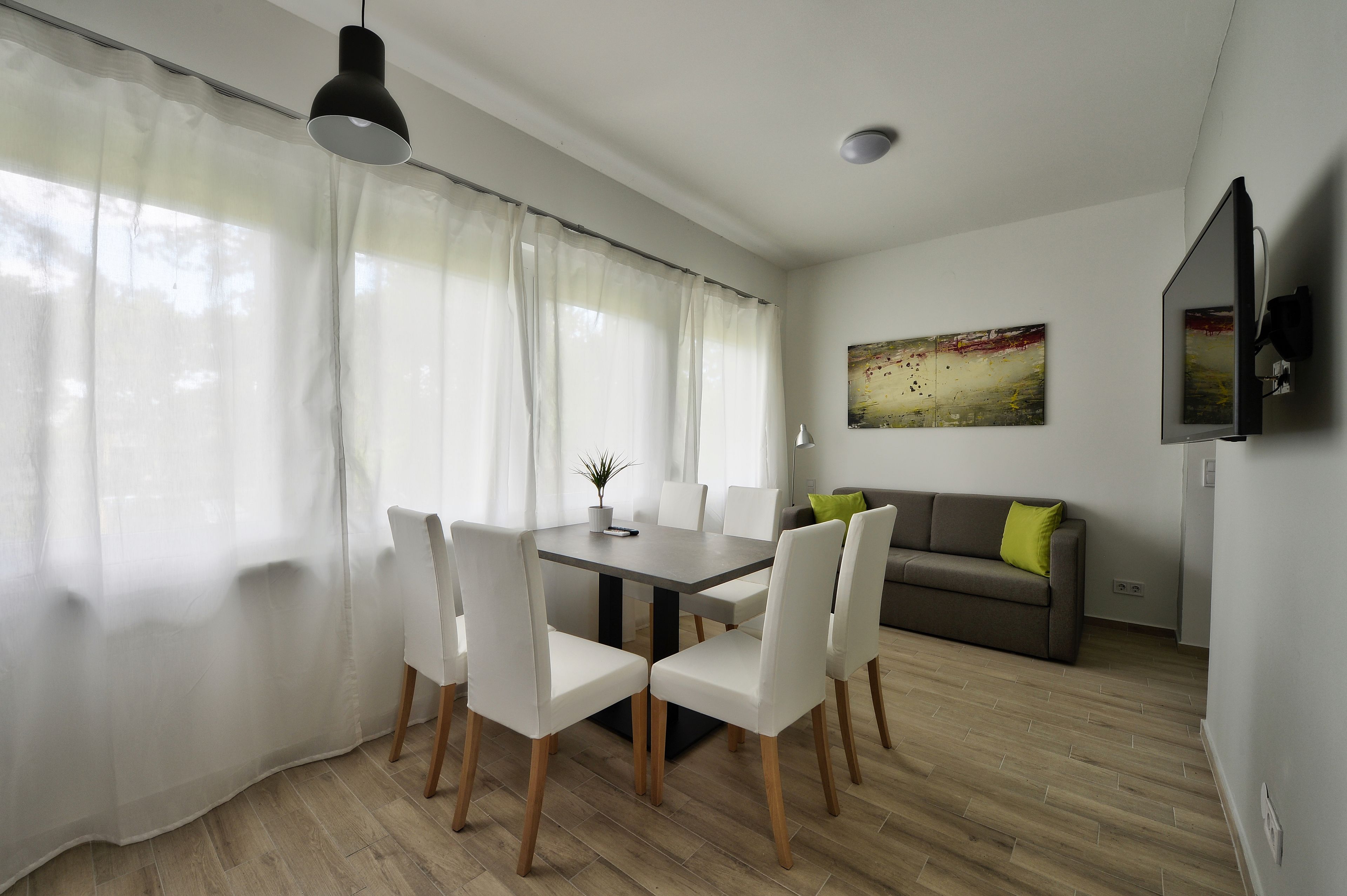 A dining area with a table, chairs, and a sofa.