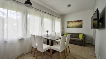 A dining area with a table, chairs, and a sofa.