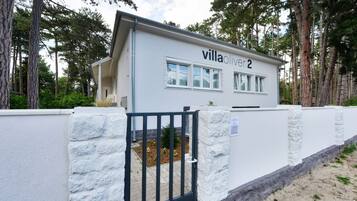 Eine Villa namens "villa oliver 2" mit einer Steinmauer und einem schwarzen Tor.