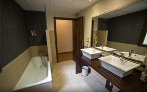 A modern bathroom with a large bathtub, two sinks, and a mirror. - Hotel Casa Beletri (Bejar)