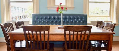 A dining area with a wooden table, six chairs, and a blue upholstered bench.