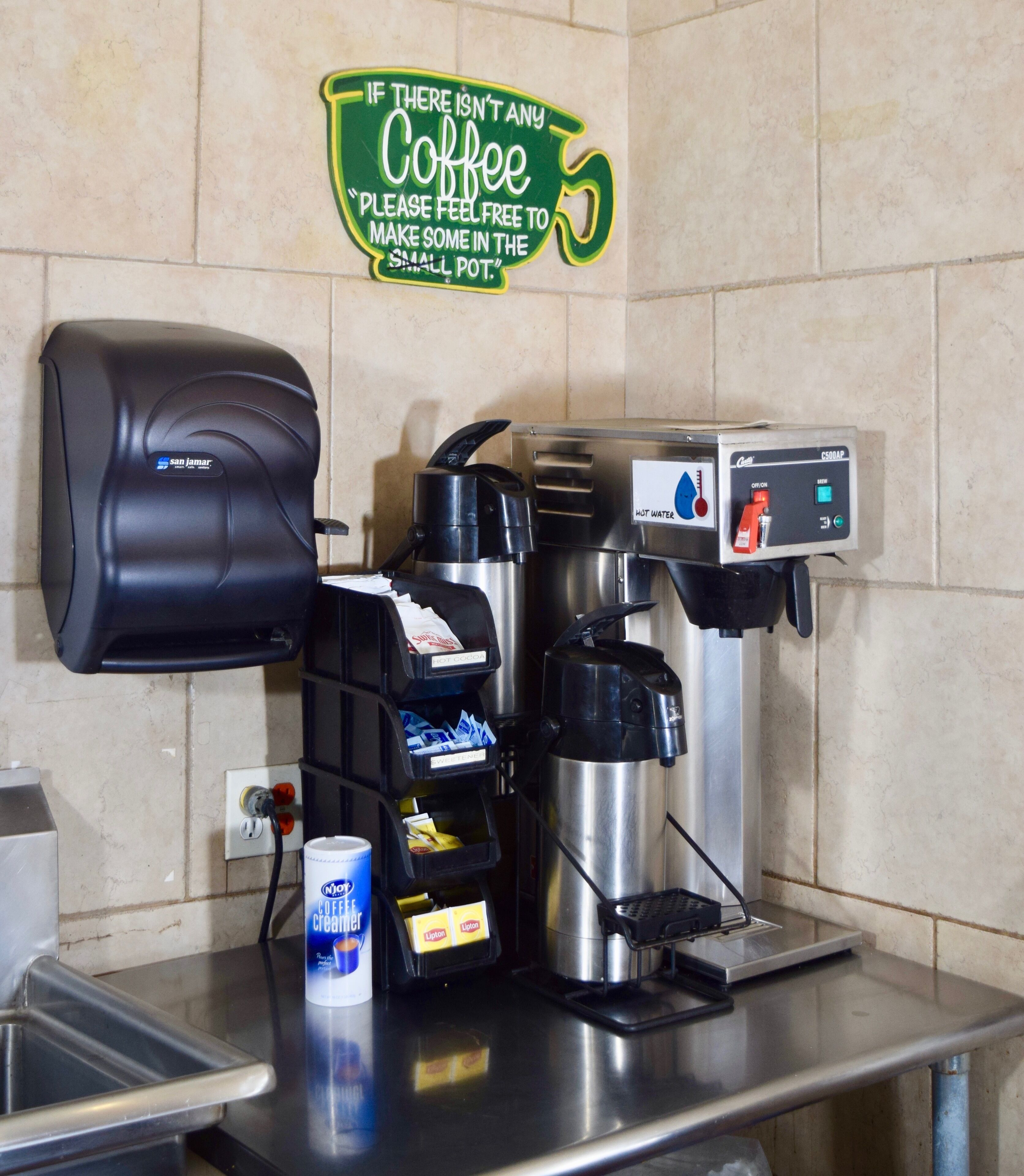 Un espace dédié au café, équipé d’une machine à café, d’un distributeur d’eau chaude et d’un distributeur de café.