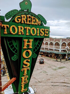 A sign for the Green Tortoise Hostel with a green and yellow design, featuring a tortoise graphic. - Green Tortoise Hostel Seattle (Seattle)