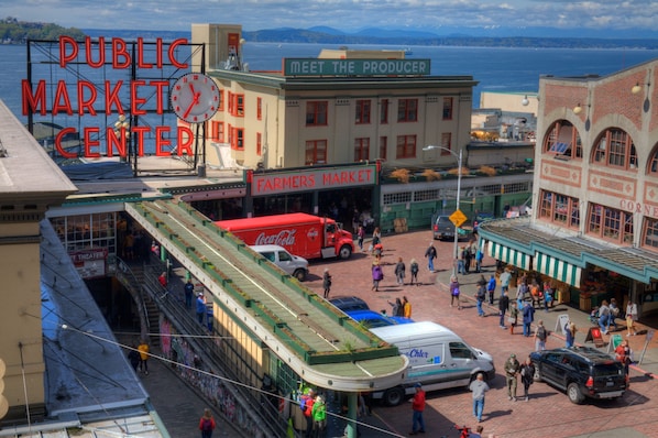 A public market center with a Farmers Market, a Coca-Cola truck, and a tram.