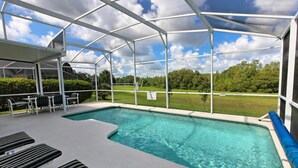 A covered outdoor swimming pool with lounge chairs and a view of the surrounding landscape. - 1842 NHD (Davenport)