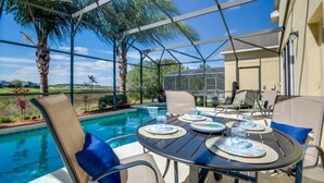 Un espacio al aire libre techado con piscina, asientos y vistas al paisaje.