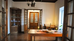 A traditional dining area with a wooden table, chairs, and a candle-lit table setting. - Quinta Minuvida Orchard Lodge (Ribeira Grande)